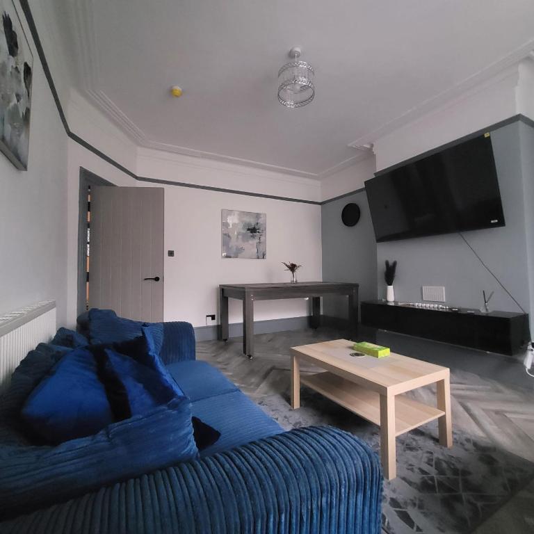 a living room with a blue couch and a table at 6 BR Home Free Parking Sleeps 14 Table Tennis City Centre Pool Table in Central Station