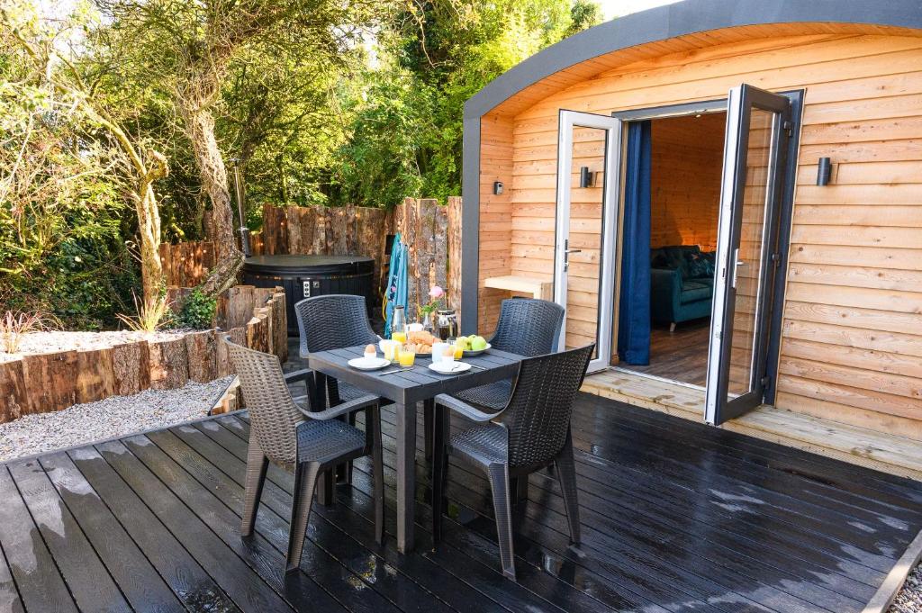 a patio with a table and chairs on a deck at Rowan in Whithorn