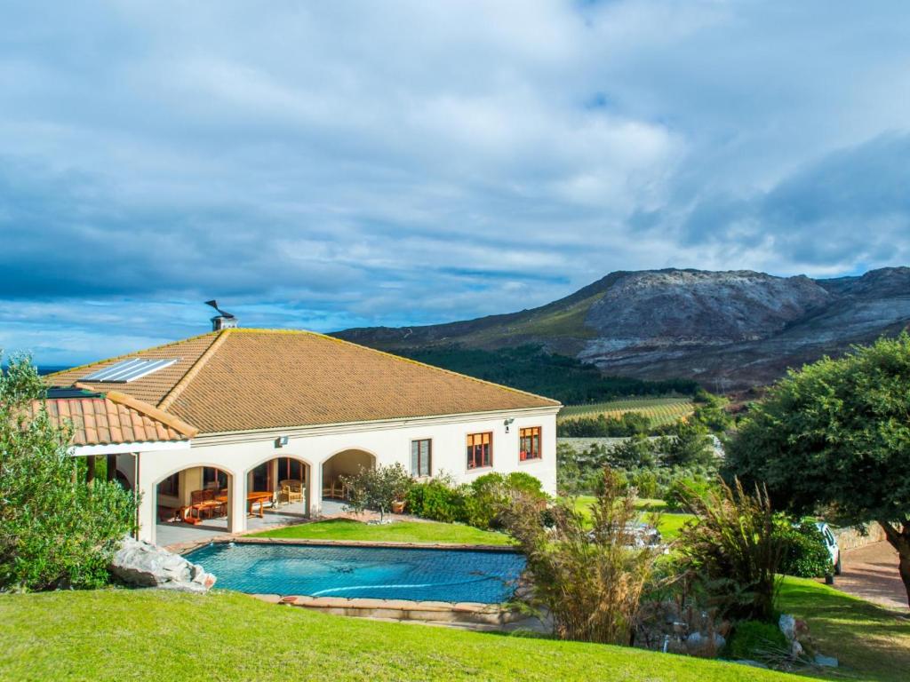 a house with a swimming pool and mountains in the background at Barton Luxury Villas in Hermanus