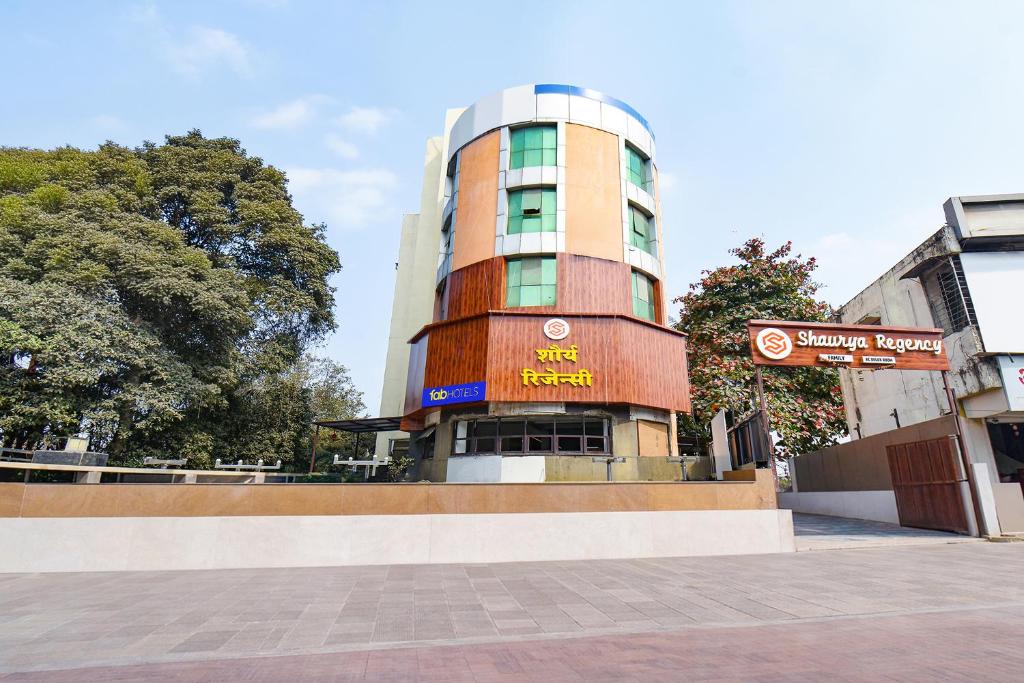 a tall building with a sign in front of it at FabHotel Shourya Regency in Jāmb