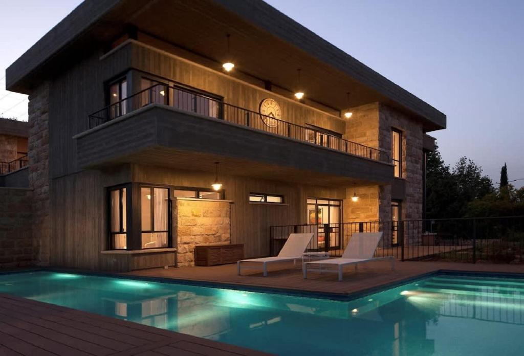 ein Haus mit einem Swimmingpool davor in der Unterkunft Villa Pnai in Rosch Pina