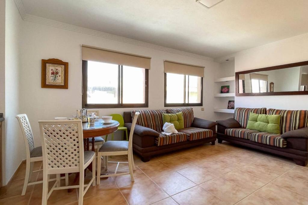 a living room with two couches and a table and a dining room at Lamar Suites in Arinaga