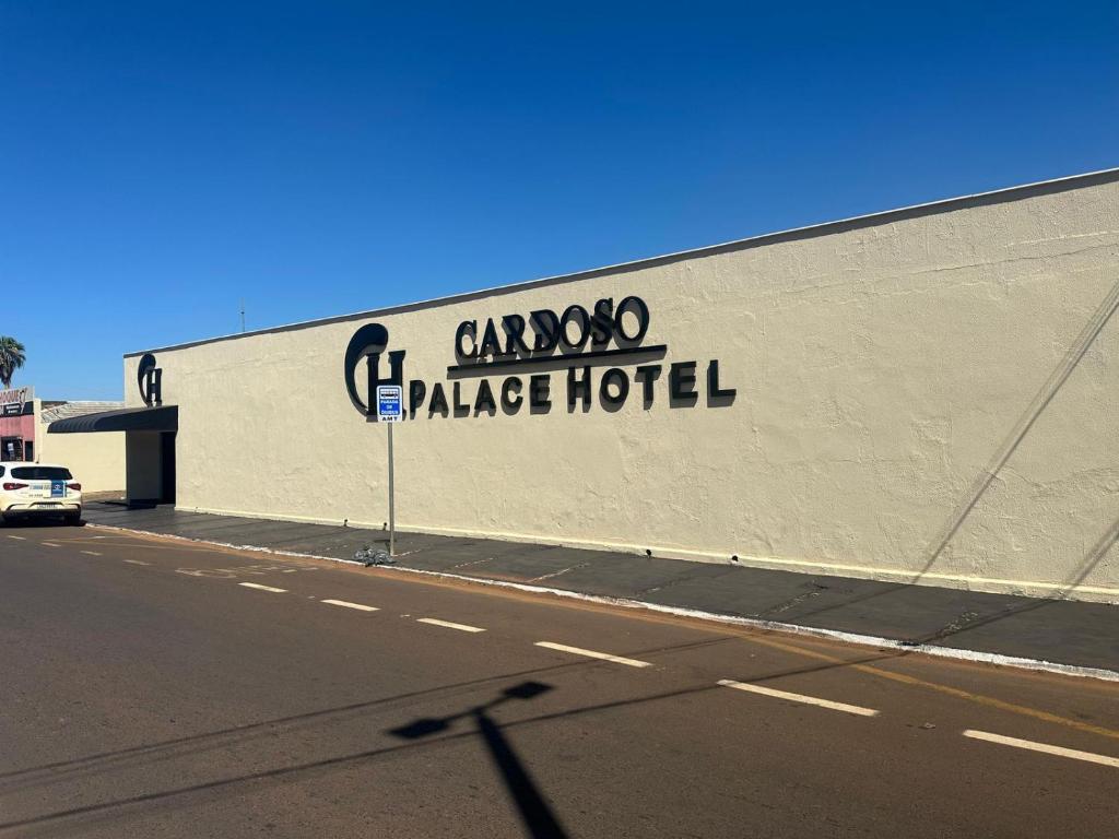 a building with a sign on the side of it at Cardoso Palace Hotel Ouro Verde in Rio Verde
