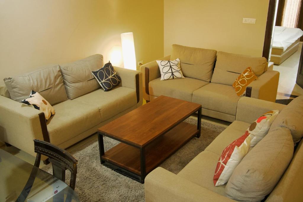 a living room with couches and a coffee table at Amur Stay 2 in Sohāna