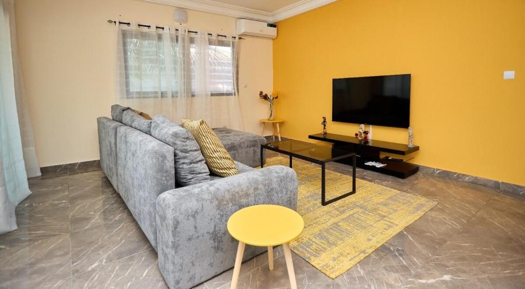 a living room with a couch and a tv at La Samurai House Assinie in Assinie