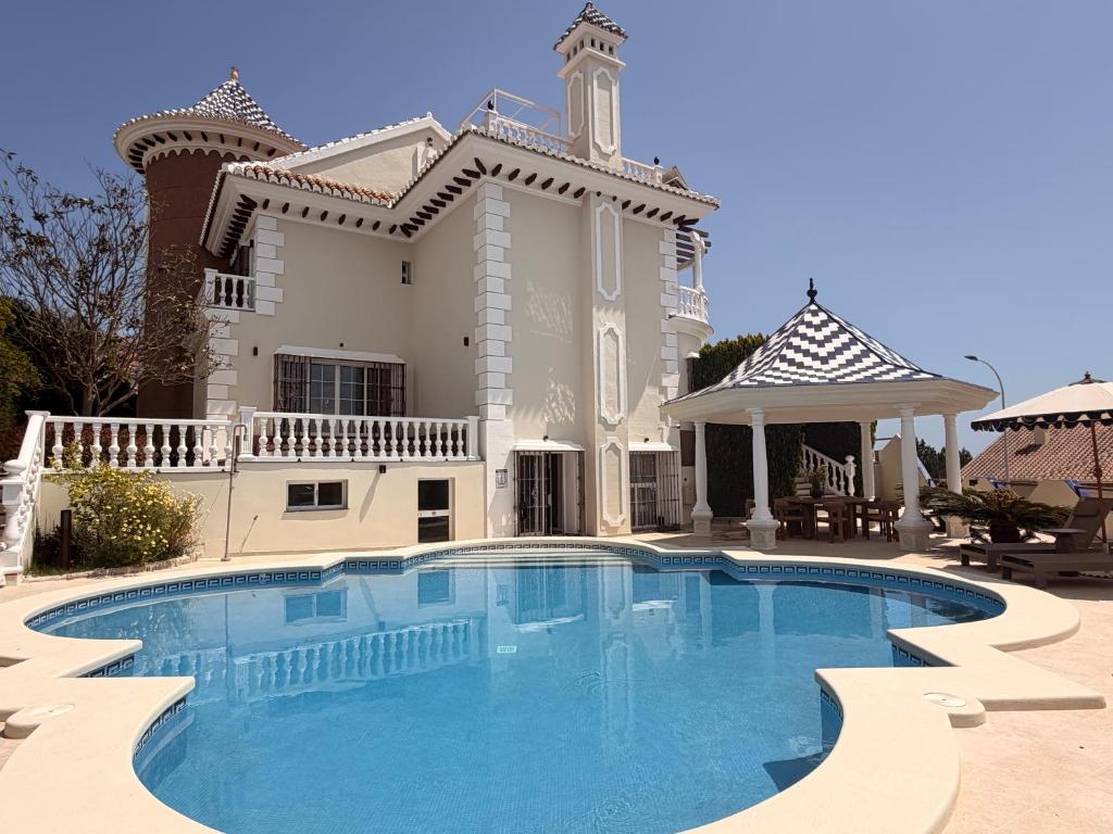 a large house with a swimming pool in front of it at CASABA - Boutique - Torre del Mar in Torre del Mar