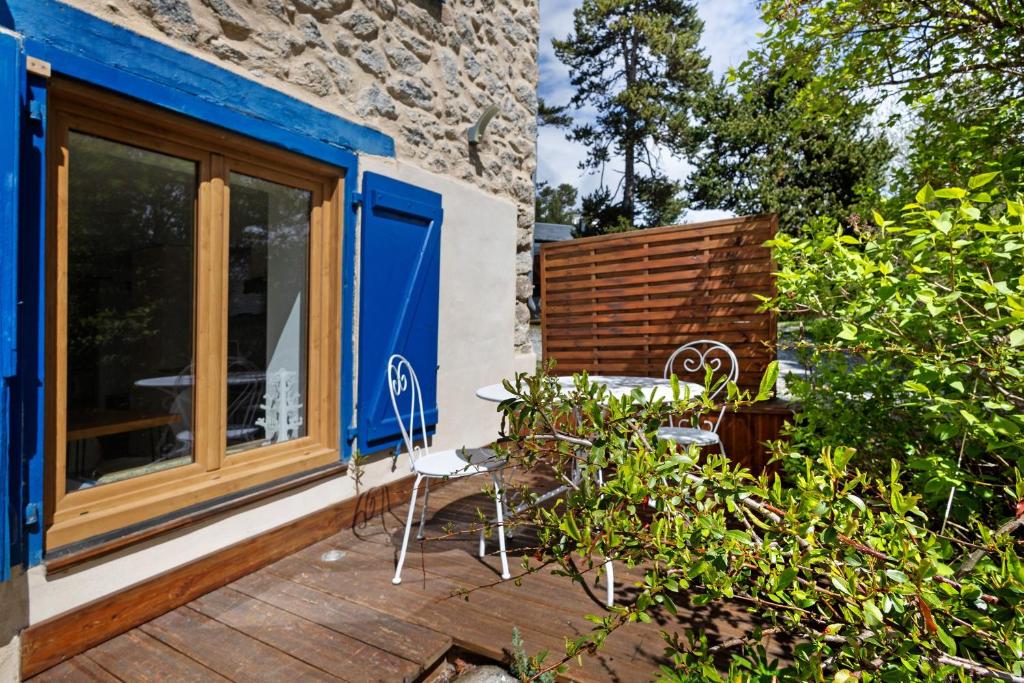 a patio with chairs and a window and a table at Sorbier Des Oiseaux in Font-Romeu