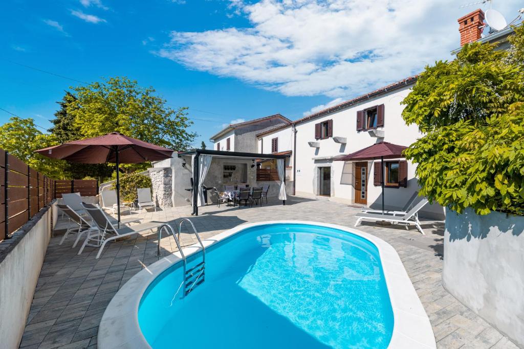 a swimming pool in the backyard of a house at Villa Franka with heated pool in Milohnići