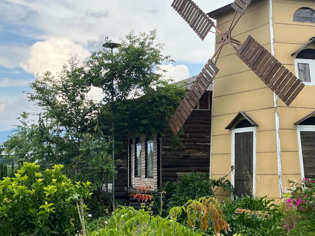 a house with a windmill in the front yard at Peaceful Waterfall Homestay - Nhà Bên Thác in Hoat