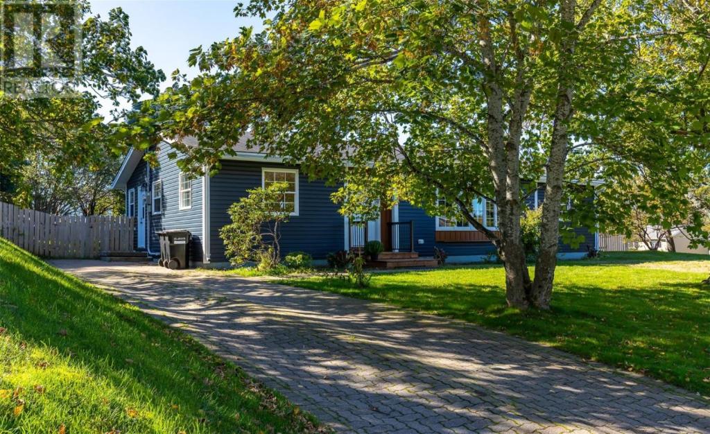 a blue house with a tree and a driveway at St Andrews Guest Home in St. John's