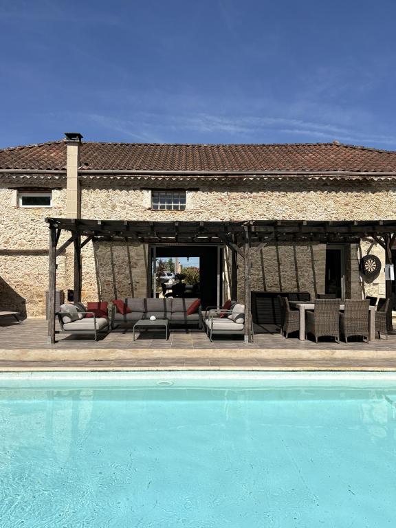 a pool in front of a house with a pavilion at Le Jardin d'Elusa in Eauze