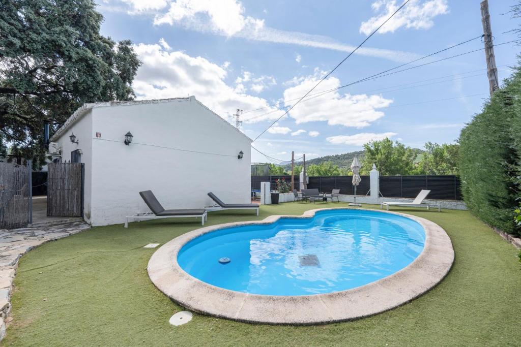 a swimming pool in the yard of a house at Casa El Mure in Ronda