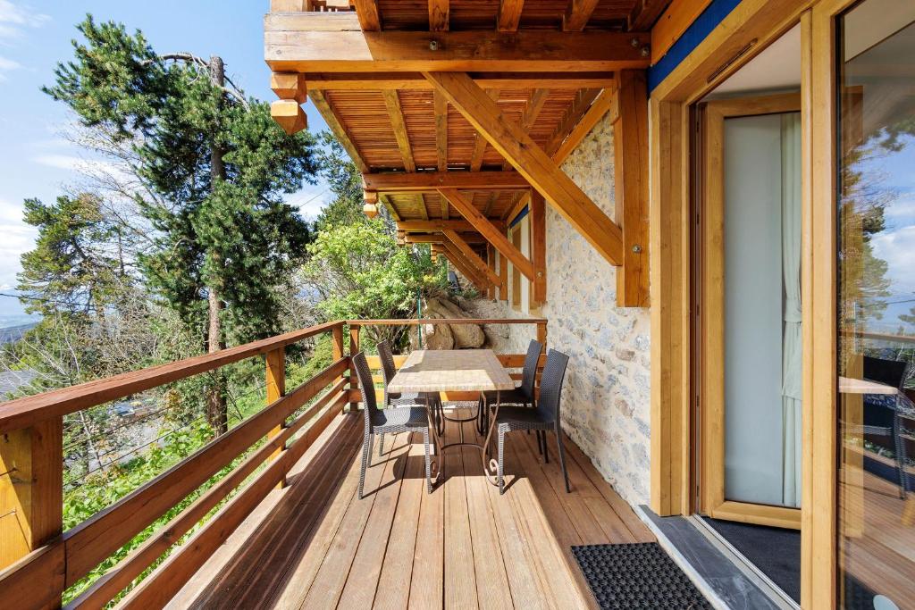a wooden deck with a table and chairs on it at Lis Martagon in Font-Romeu