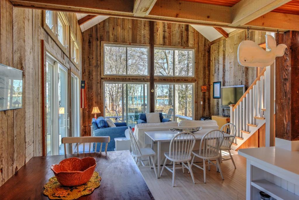 a dining room and living room with wooden walls at Sun Serenity at A Wave From It All in Pocasset