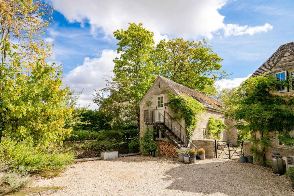 an old house with a staircase in front of it at The Barn in South Cerney