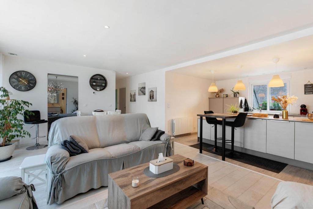 a living room and kitchen with a couch and a table at Macleo proche plage in Plougasnou