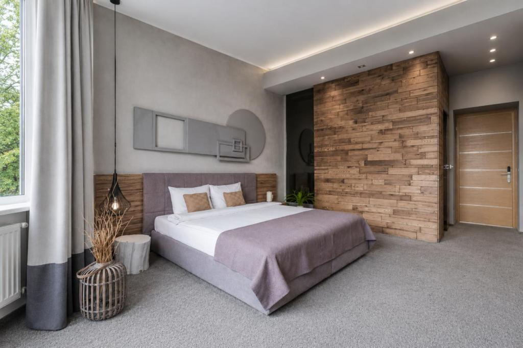 a bedroom with a large bed and a brick wall at Poet Art Hotel in Odesa