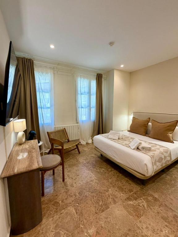 a bedroom with a large bed and a living room at VTZ The Orus Factory Hotel - Parking Muy Económico in Zaragoza