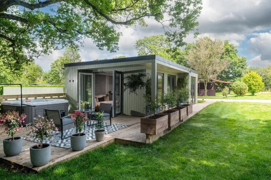 a tiny house with a deck in a yard at Badgers Sett in Hankerton