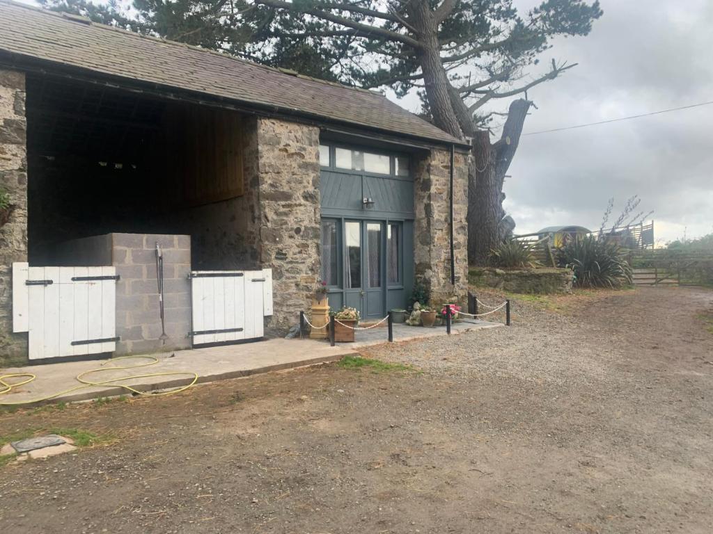 a stone house with a large window and a tree at The Stable Sleeps 2 with Parking in Llanfairpwllgwyngyll
