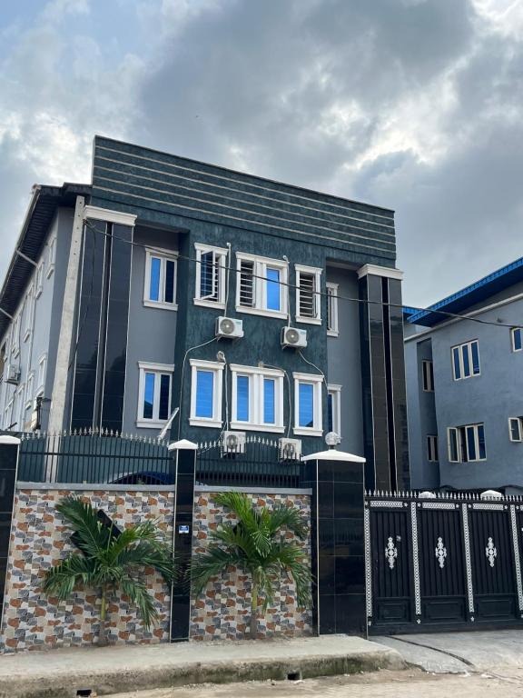 a house with a black fence and a building at Urban Nest Lodge in Ikeja