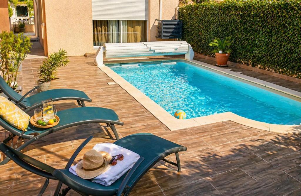 a swimming pool with chairs and a table and a table at Loge au ptitbonheur in Savasse