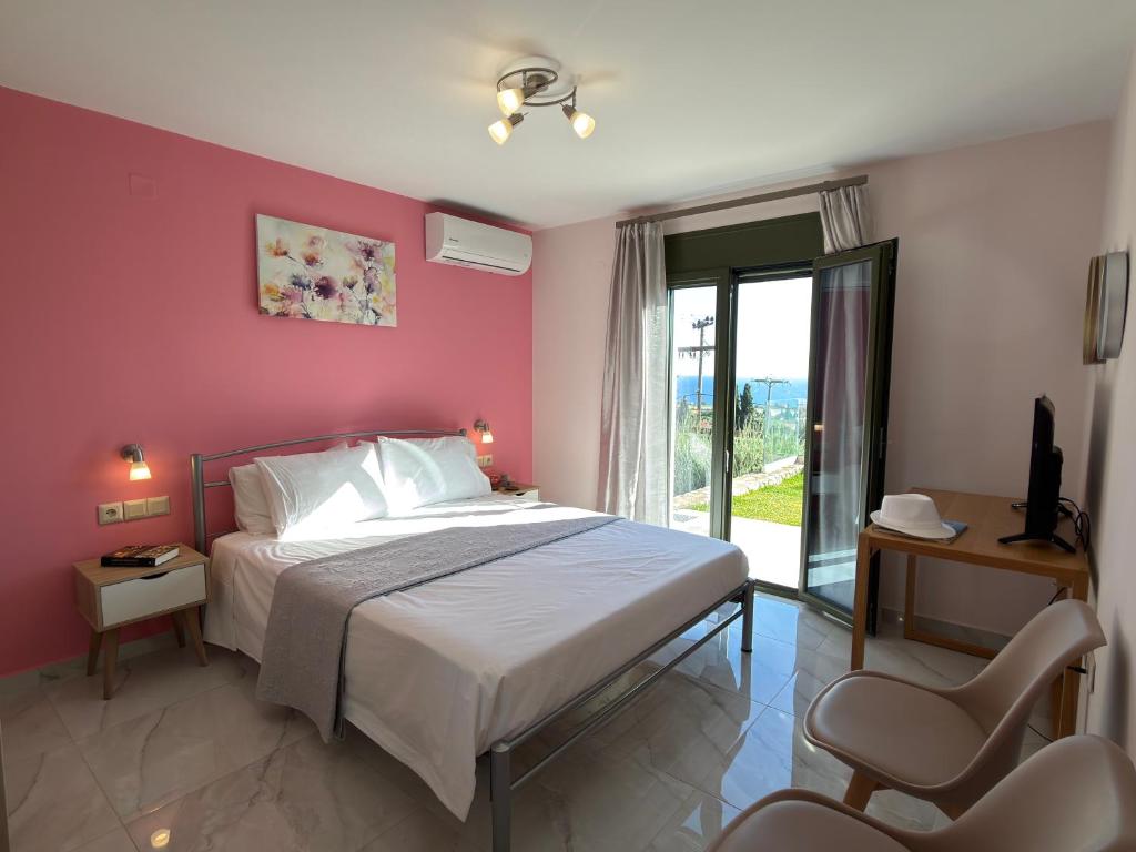 a bedroom with a bed with a pink wall at Freesia Grand Sea View Residence in Sarláta