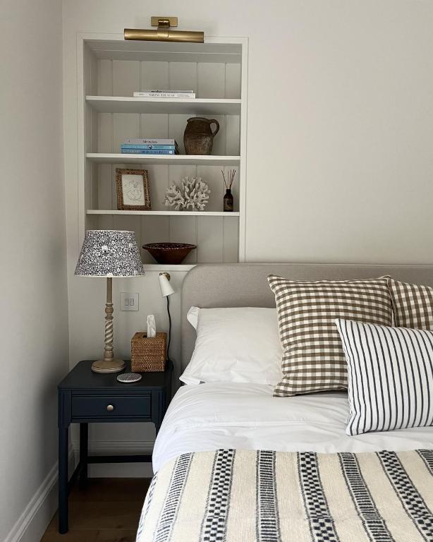 a bedroom with a bed and a table with a lamp at Stamping Cottage Studio Between St Ives & Penzance in Penzance