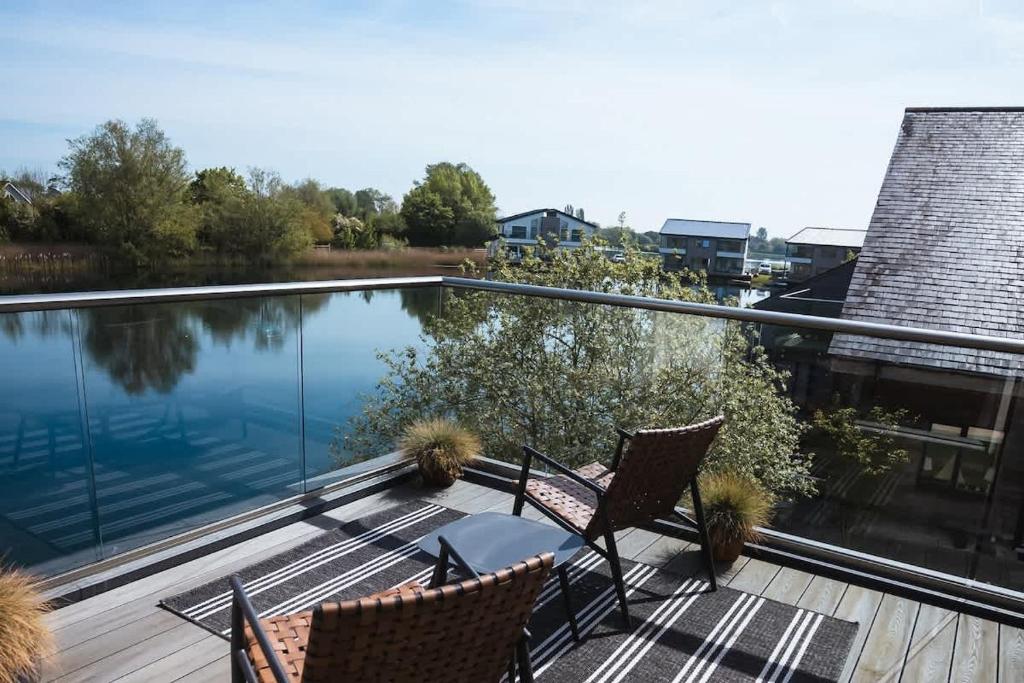 ein Balkon mit zwei Stühlen und ein Swimmingpool in der Unterkunft Maricor in South Cerney