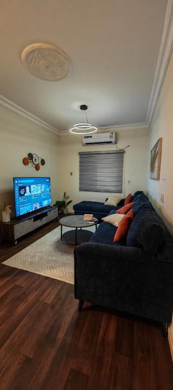 a living room with a couch and a flat screen tv at شقق الفيصل in Al Khobar