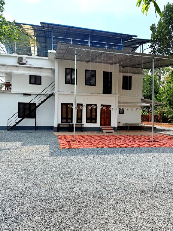 a large white building with a red carpet at Nariman's riverstone hevan Resort in Kelakam