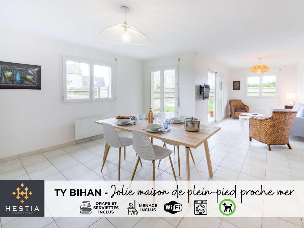 a dining room and living room with a table and chairs at TY BIHAN - Charmante maison de plein-pied proche mer in Ploudalmézeau