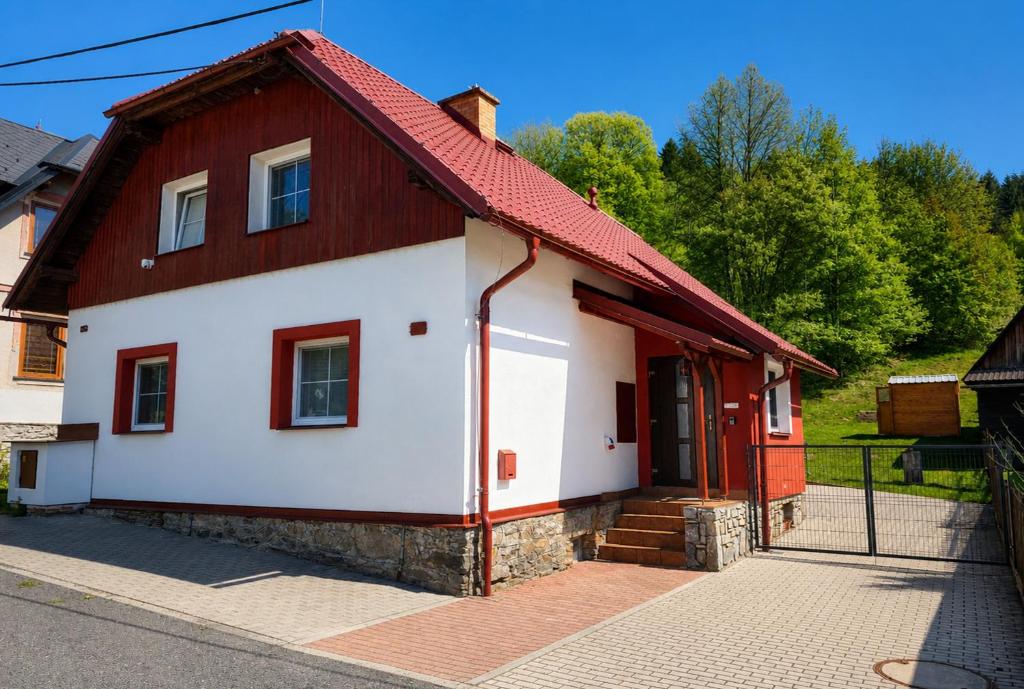 a red and white house with a red roof at Chalupa v Oblacích in Jindřichov