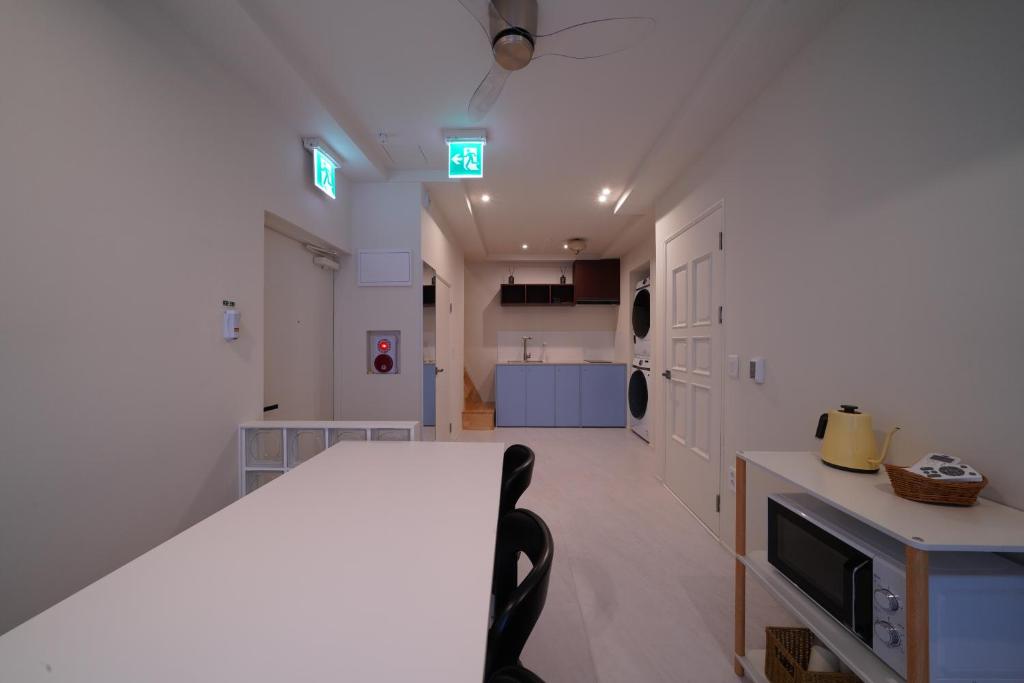 a large white kitchen with a table and a chair at Covon Stay in Busan