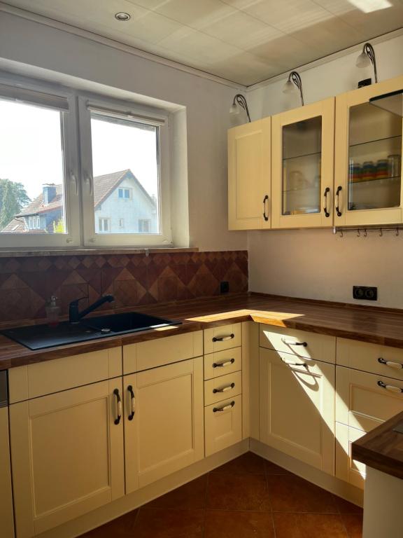 a kitchen with white cabinets and a sink and a window at Ferienwohnung Fatlume 2 in Bad Honnef am Rhein