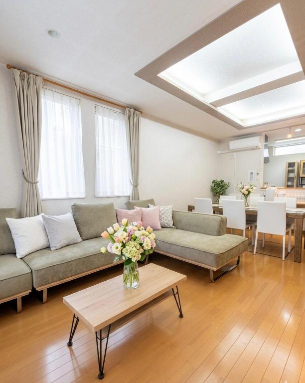 a living room with couches and a table with flowers at Sapporo Nakajima Parkhouse in Sapporo
