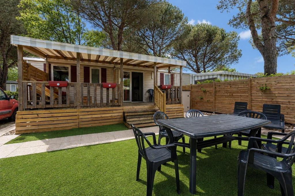 a cabin with a table and chairs in a yard at Mobil-home Badji in Gastes