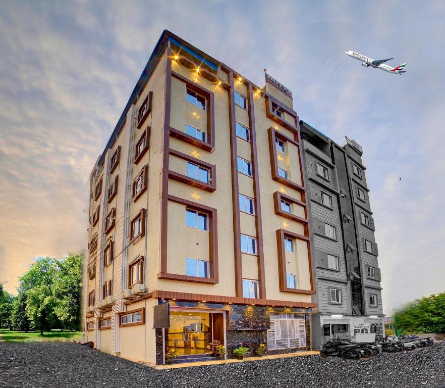 a building with an airplane flying in the sky at RedKEY Inn Transit Hotel Bangalore Airport in Bangalore