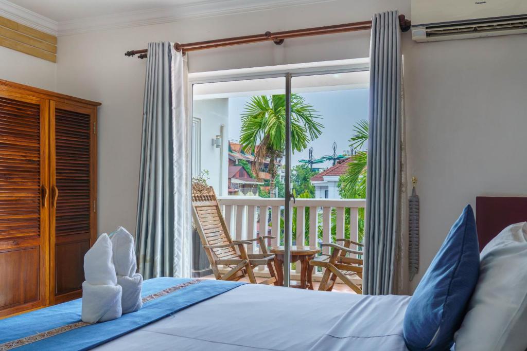 a bedroom with a bed and a balcony at Bou Phanith Villa in Siem Reap