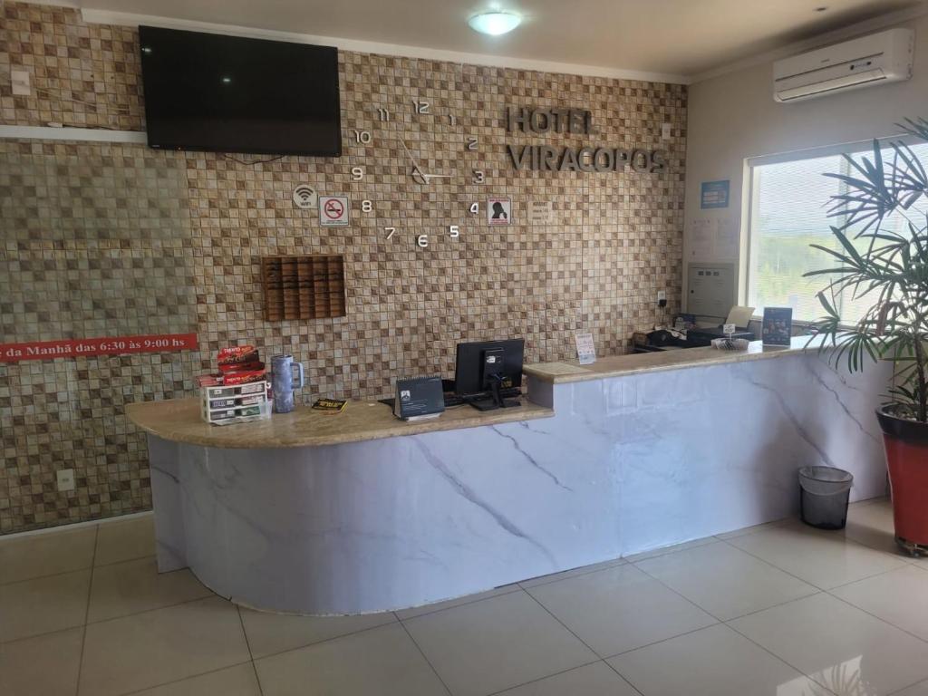 a restaurant with a reception counter in a room at Hotel Viracopos de Indaiatuba in Indaiatuba