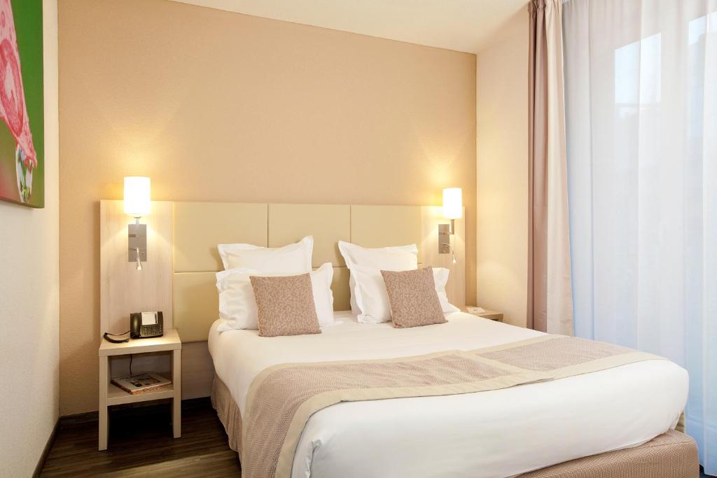 a bedroom with a large white bed with two pillows at Residhome Neuilly Bords De Marne in Neuilly-Plaisance