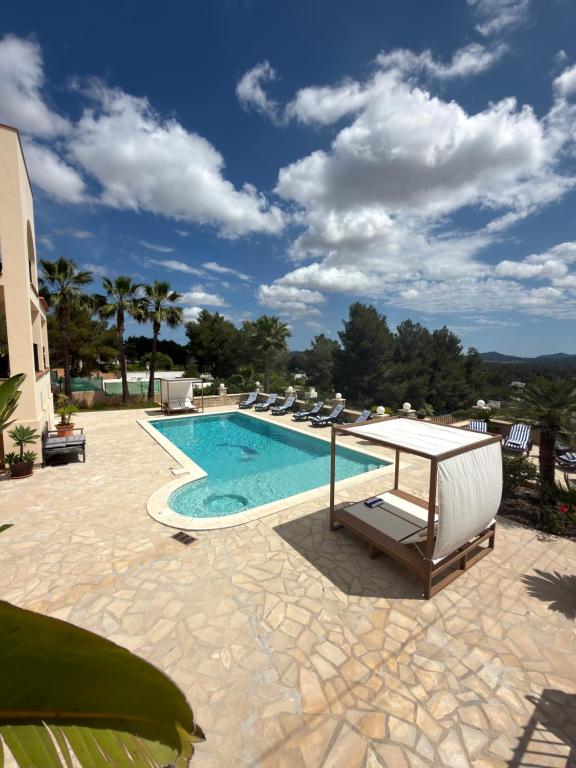 a swimming pool with lounge chairs and a table at Beautiful Villa Rafaella in Sant Rafael de Sa Creu