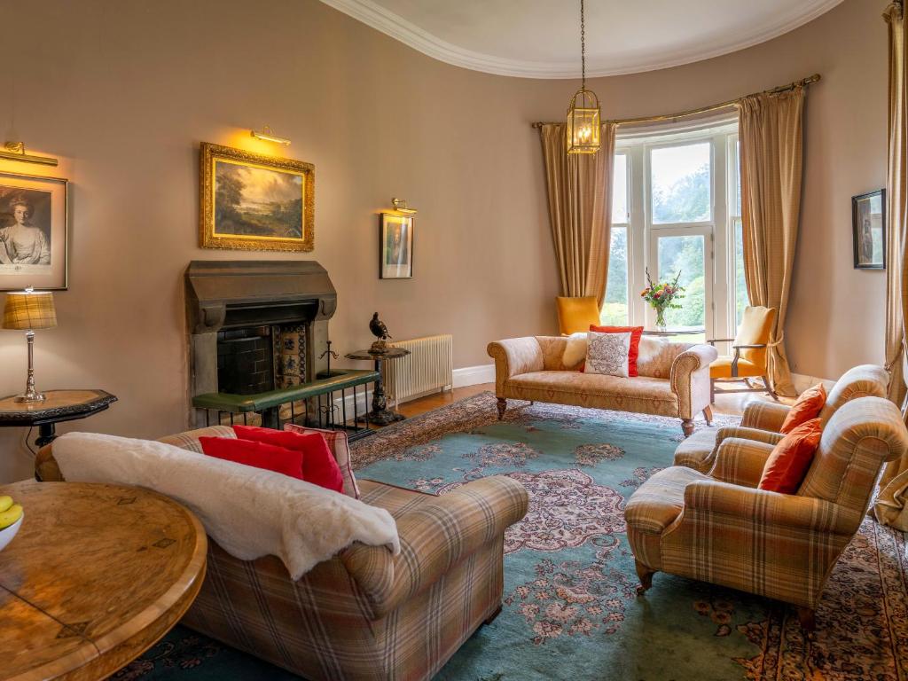 a living room with couches and a fireplace at Dalnaglar Castle - Uk7072 in Cray