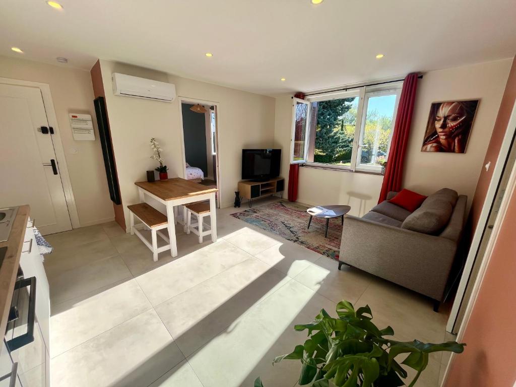 a living room with a couch and a table at Appartement proche Eurexpo Aéroport Genas Centre in Genas