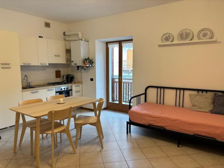 a room with a table and a bed and a kitchen at Appartamento Nicoletta in Portolo