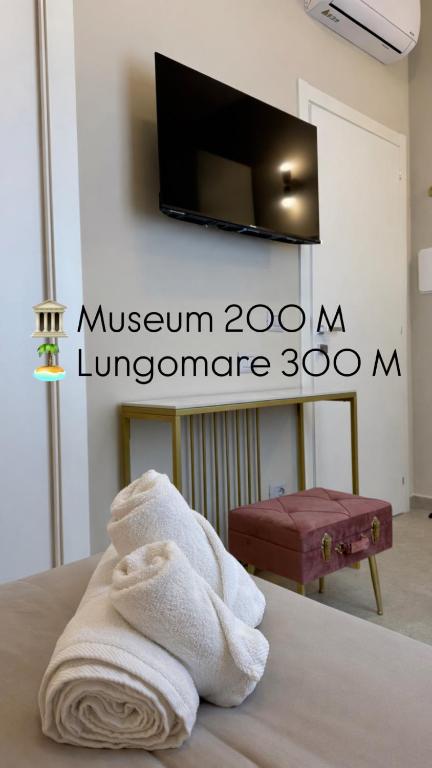a room with a towel on a bed with a television at Maison ì room, suite & apartment in Reggio di Calabria
