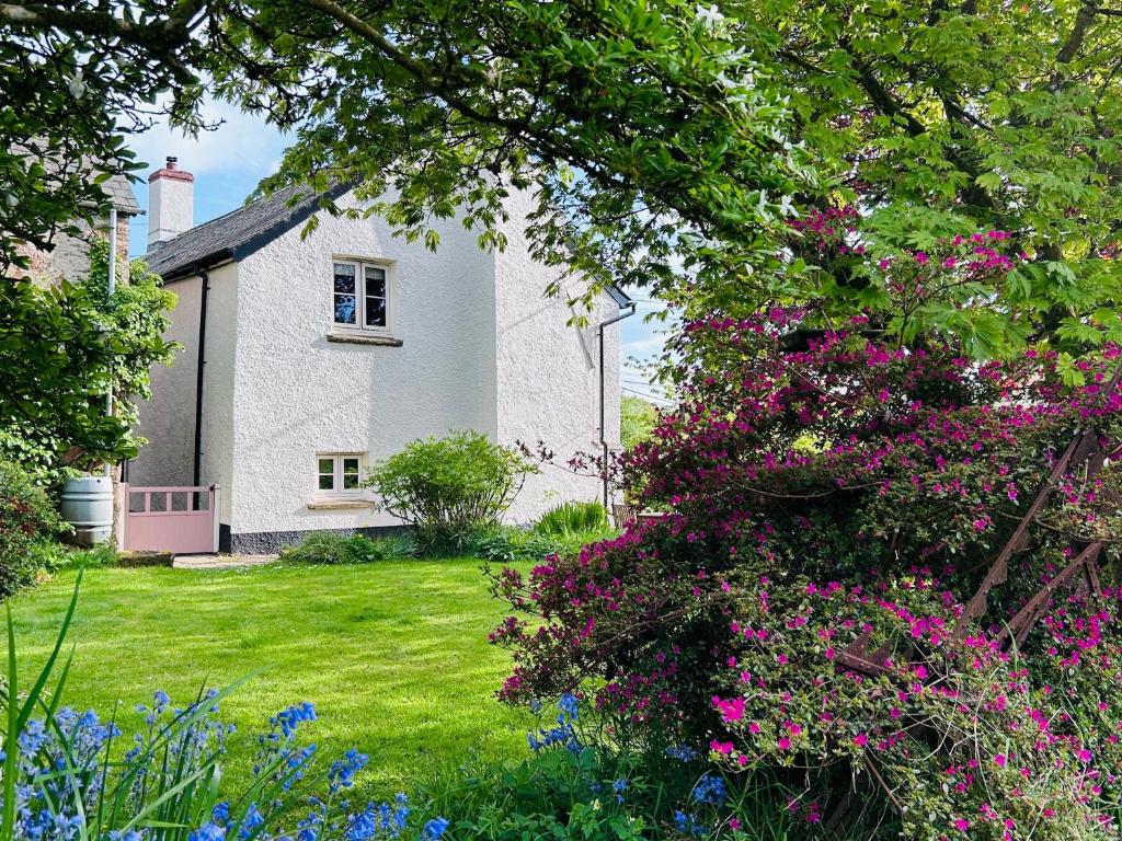 a house with pink flowers in the yard at Hare and Hounds Exton in Exton