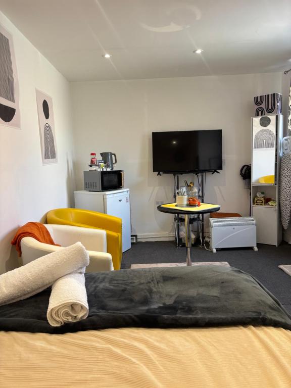 a bedroom with a bed and a tv and a table at Self-Contained Studio with Ensuite & Private Access in Hardwicke