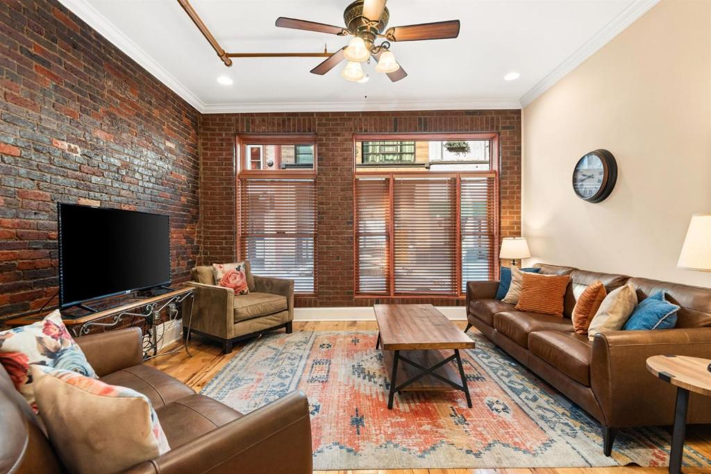a living room with a brick wall at The Dolly Printer's Alley Nashville- 2 Blocks to Broadway in Nashville
