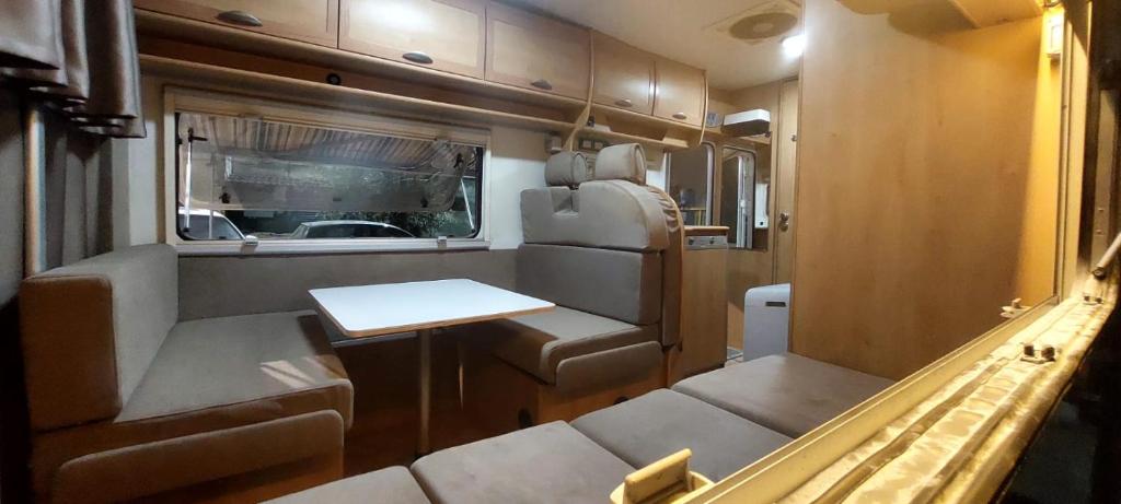 an interior view of an rv with a table and seats at Camper Rental Elbasan in Elbasan